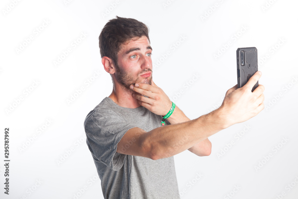 Joven haciéndose un selfie con un teléfono inteligente Joven haciéndose un selfie con un teléfono inteligente