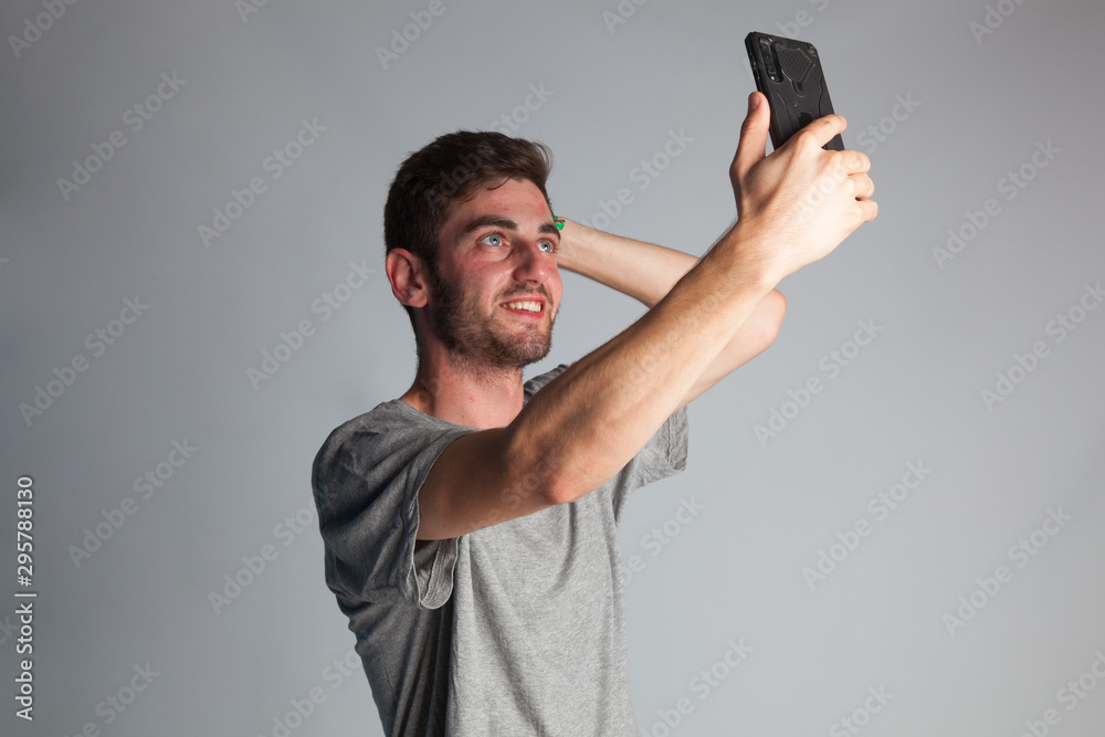 Joven haciéndose un selfie con un teléfono inteligente Joven haciéndose un selfie con un teléfono inteligente