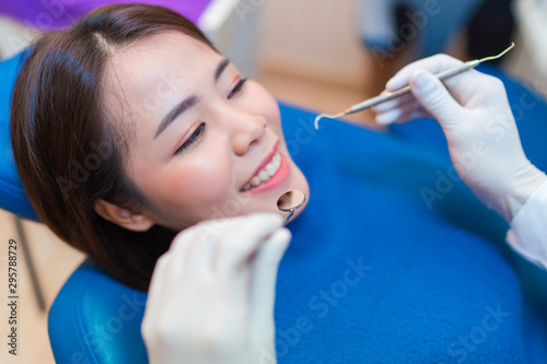 Closeup smile of woman having dental teeth examined dentist check-up via excavator in Clinic her patient