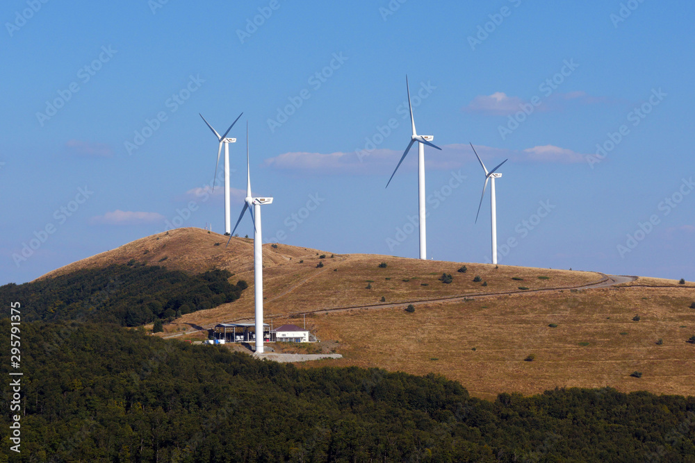 Wind generators in the mountains. Blue sky and white clouds for background. Wind generators in the mountains. Blue sky and white clouds for background.