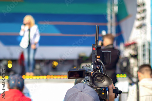 The operator shoots a concert performance on the street scene during the day