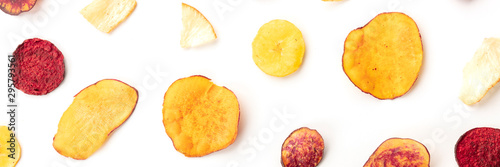 A panorama of dry fruit and vegetable chips, shot from the top on a white background. Healthy vegan snack, an organic food flat lay