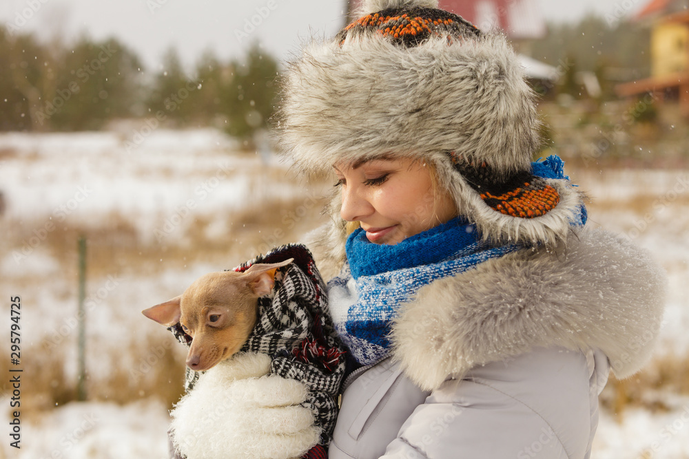 Woman hug warming her little dog in winter Woman hug warming her little dog in winter