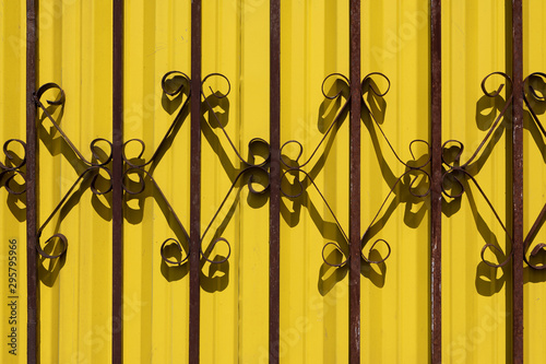 Wrought iron railing against vibrant yellow wall