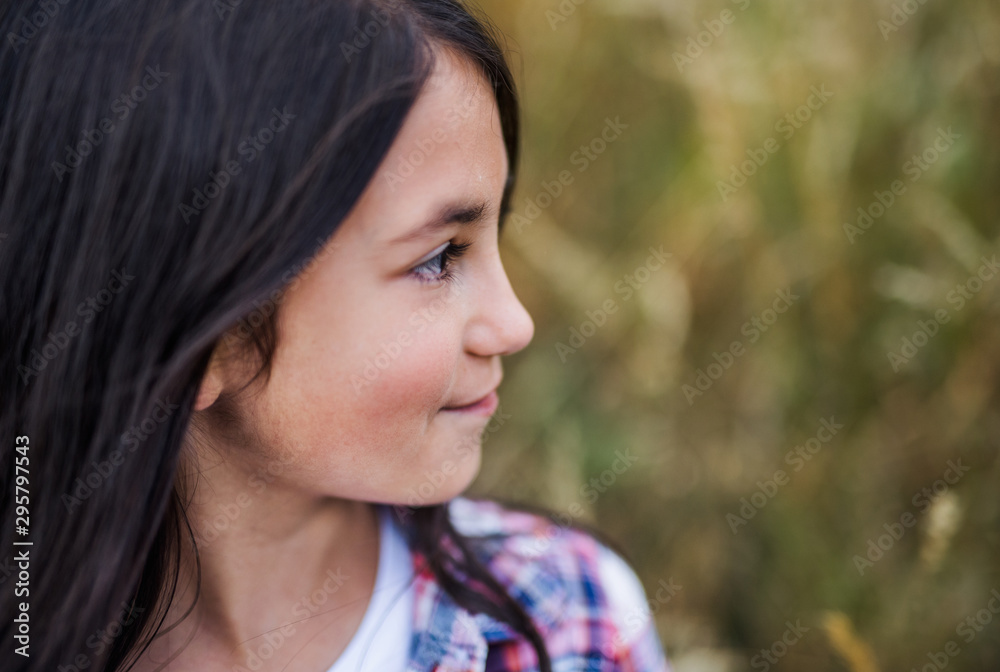 A school child standing on field trip in nature, headshot. Copy space.