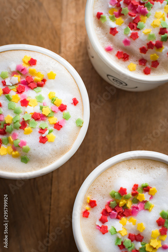 Coffee cups with foam decorated with colored stars.