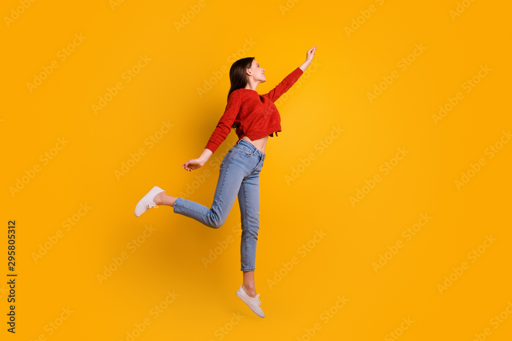 Full length photo of positive cheerful lovely girl jump hold hand want catch her flying parasol star wear good looking clothing isolated over yellow color background - obrazy, fototapety, plakaty 