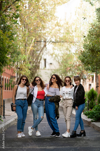 Five female friends laughing in the street