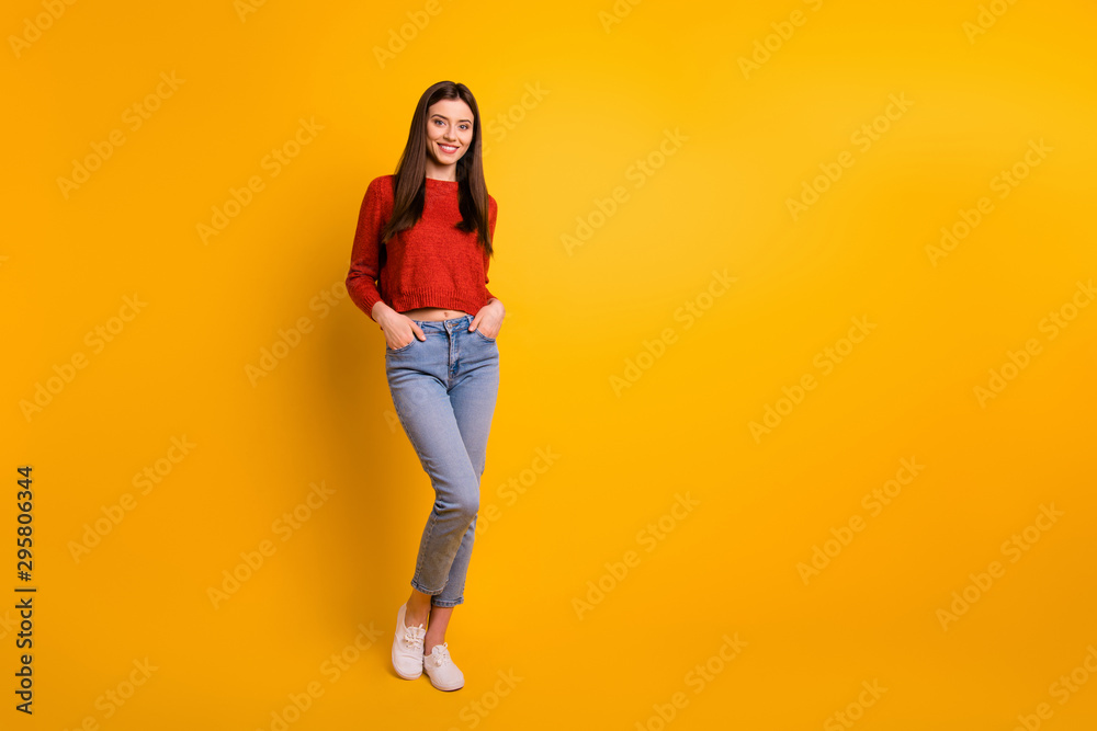 Full length body size photo of cute nice attractive millennial youngster with hands in pockets standing near empty space smiling toothily isolated over vivid color background - obrazy, fototapety, plakaty 
