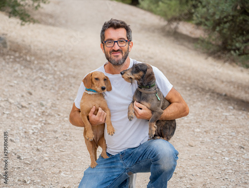 Photography Happy owner man with two old cute Dachshund Dog dogs in the park