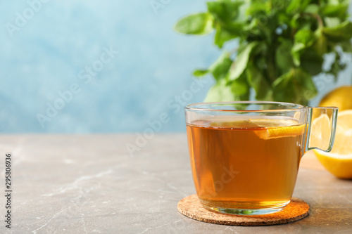 Cup of tea, lemon and mint on grey background, space for text