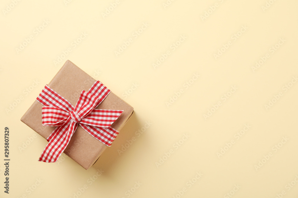 Gift box with bow on color background, space for text Gift box with bow on color background, space for text