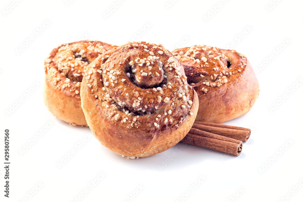 Three cinnamon buns and cinnamon sticks isolated on white background Three cinnamon buns and cinnamon sticks isolated on white background