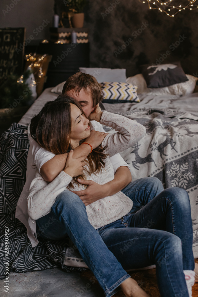 Naklejka premium Romantic couple in love feeling happiness about their romance spending christmas eve together- Image