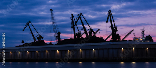 TRANSSHIPMENT TERMINAL - Port cranes on the coal quay in Gdynia at sunrise photo