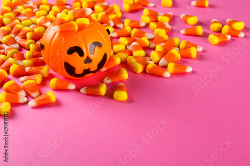 Bunch of candy corn sweets as sybol of Halloween hoiday on textured background with a lot of copy space for text. Flat lay composition for all hallows eve. Top view shot.