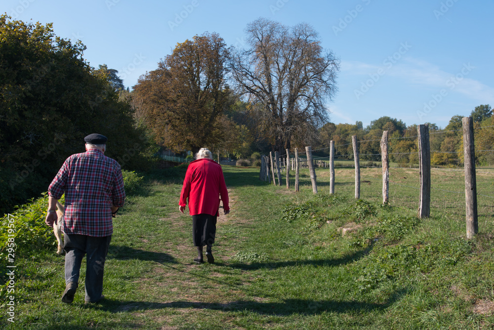couple de personnes âgées marchant sur un chemin de campagne