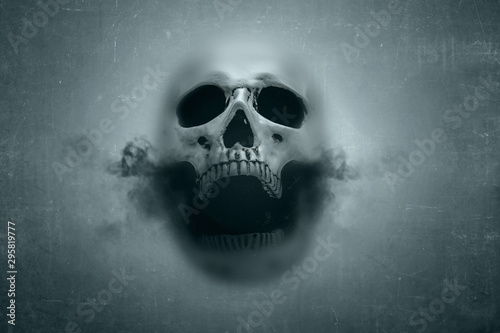 Human skull with dark smoke from his mouth behind of window glass