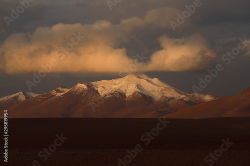 Sunset over the snow-capped volcanoes and desert landscapes in the highlands of Bolivia. Andean landscapes of the Bolivia Plateau