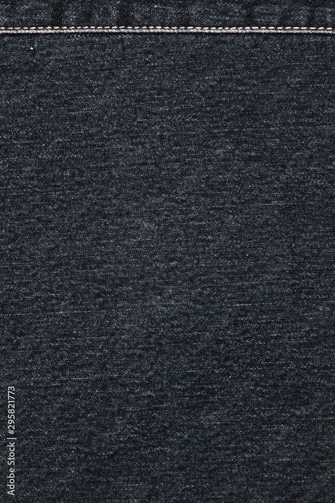 Texture of a black denim fabric with a decorative yellow topstitching. Two pieces of fabric stitched together Texture of a black denim fabric with a decorative yellow topstitching. Two pieces of fabric stitched together