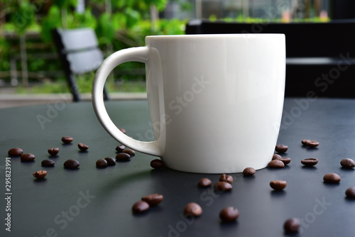 Cap of Coffee on the of dark wood table have many coffee beans. photo