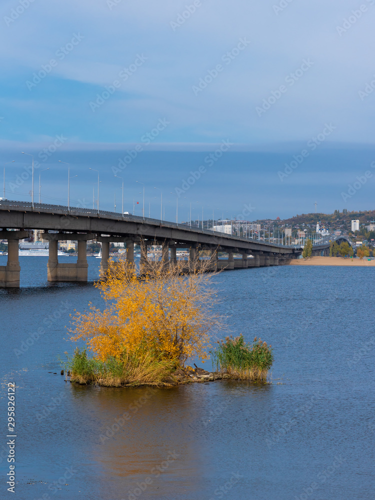 Autumn river landscape - View of the Saratov bridge and the Volga river, a small island in the foreground