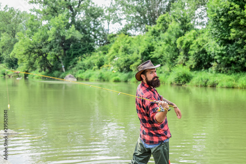 Born to Fish. hobby and sport activity. pothunter. bearded fisher in water. mature man fly fishing. man catching fish. summer weekend. Big game fishing. fisherman with fishing rod