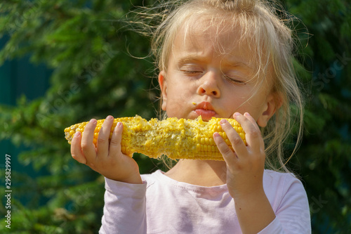 Baby girl eating boiled earn corn cob