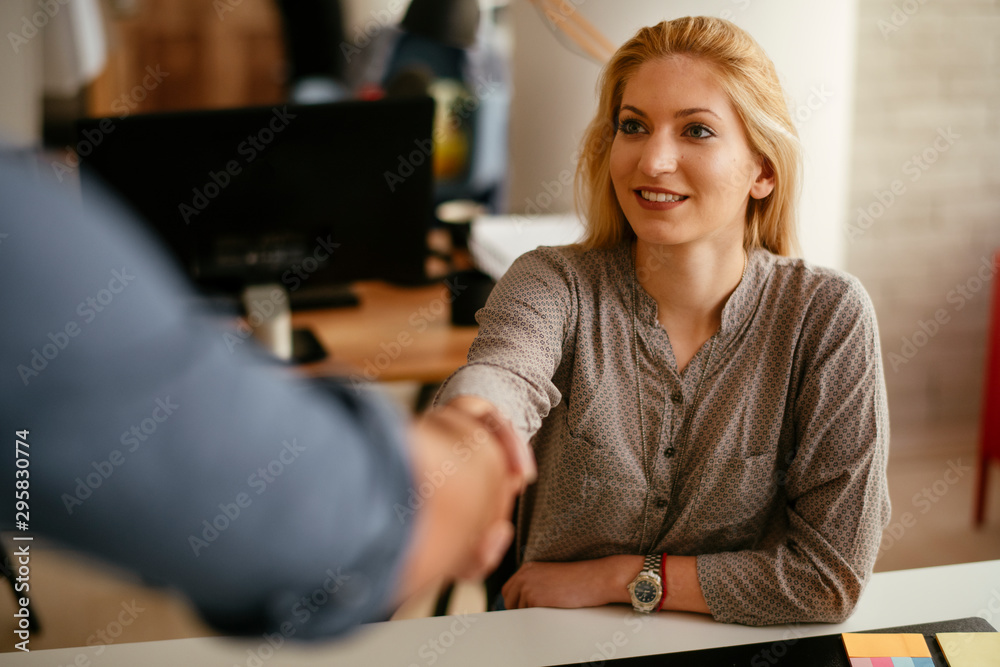 Young woman handshaking with colleague. Young woman handshaking with colleague.