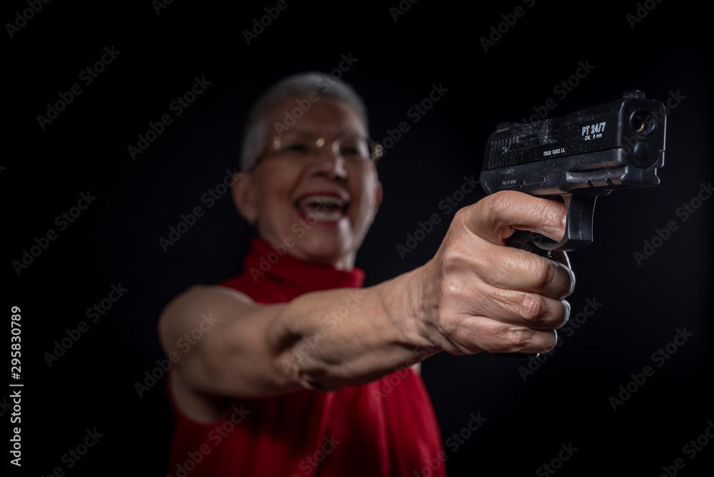 Old lady aiming with her weapon while smiling Old lady aiming with her weapon while smiling