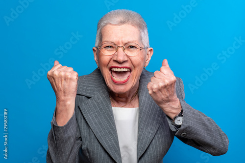 Excited old business lady celebrating some incredible news