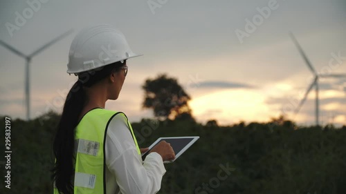 Asian engineers or technican woman are checking the wind turbine system with a tablet footage 4K