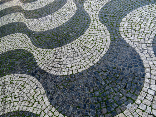 Background texture of the Typical portuguese walkway pavement with old stone in the streets of Lisbon, Portugal
