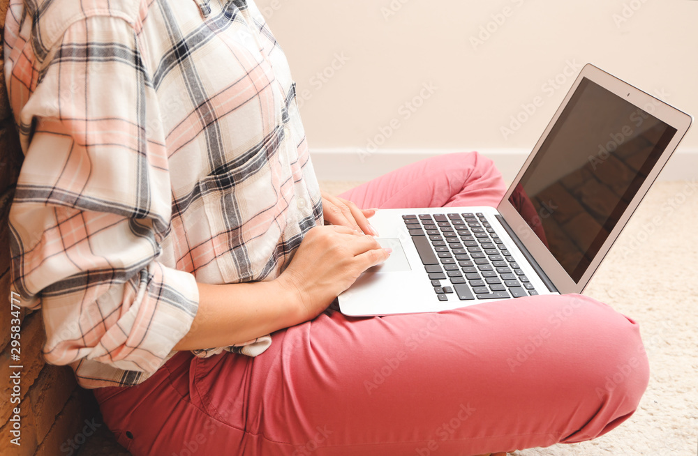Naklejka premium Young woman working on laptop at home