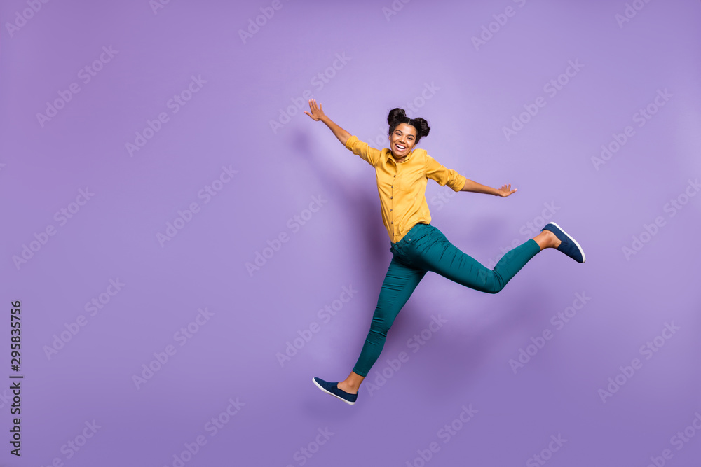 Full body profile photo of pretty dark skin lady jumping high hurrying sale shopping black friday season wear casual yellow shirt trousers isolated purple color background