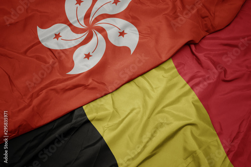 waving colorful flag of belgium and national flag of hong kong.