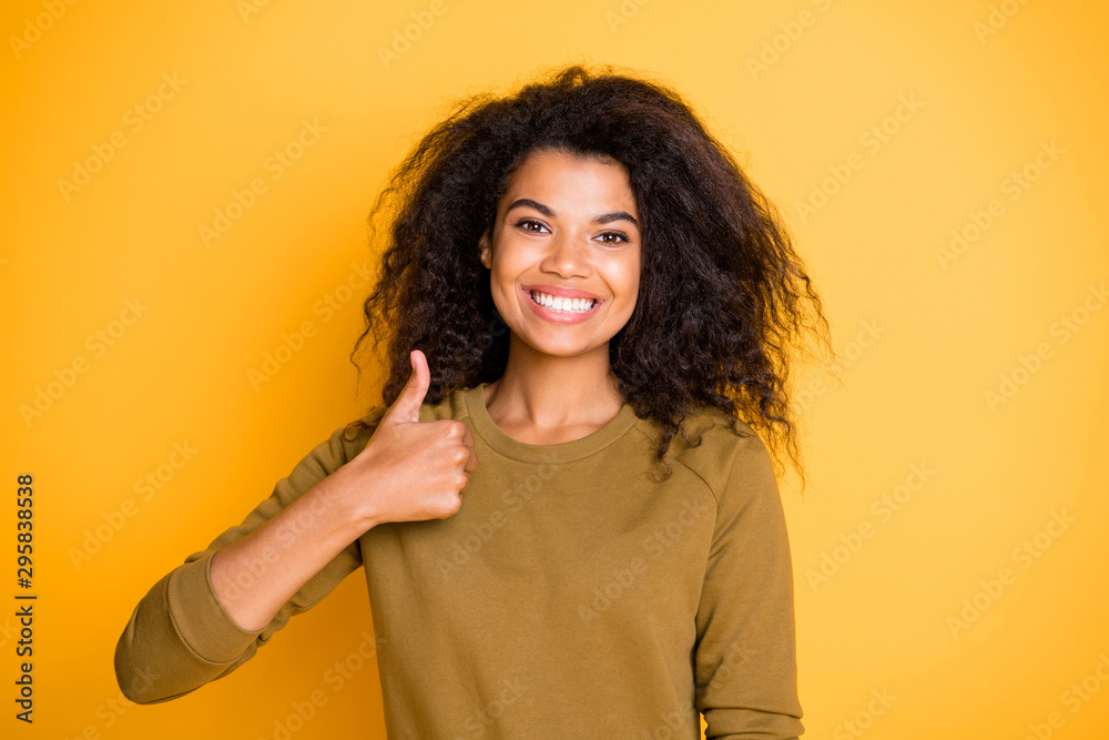 Photo of cheerful positive cute nice charming pretty black skinned girlfriend showing you thumb up demonstrating good quality and teeth isolated over vivid color background Photo of cheerful positive cute nice charming pretty black skinned girlfriend showing you thumb up demonstrating good quality and teeth isolated over vivid color background