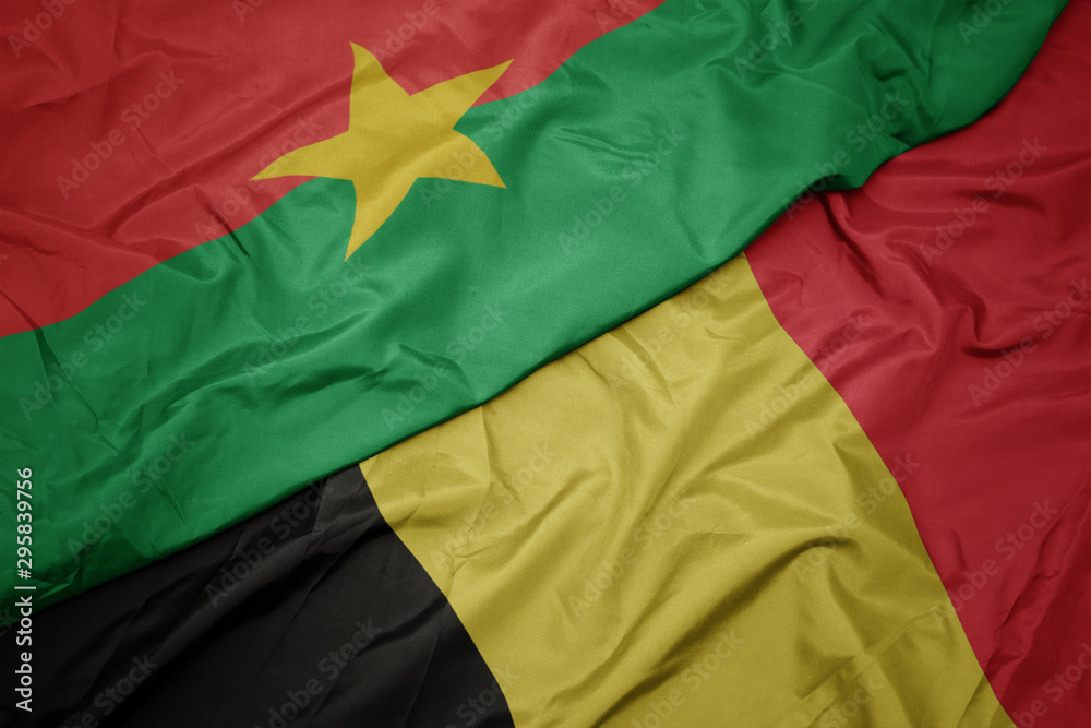 waving colorful flag of belgium and national flag of burkina faso. waving colorful flag of belgium and national flag of burkina faso.