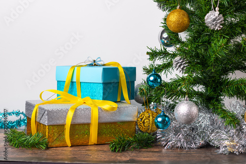 Christmas mood. Gifts packed in blue and gold color gift wrapping located on a wooden table and on a white background. Vreya give gifts.