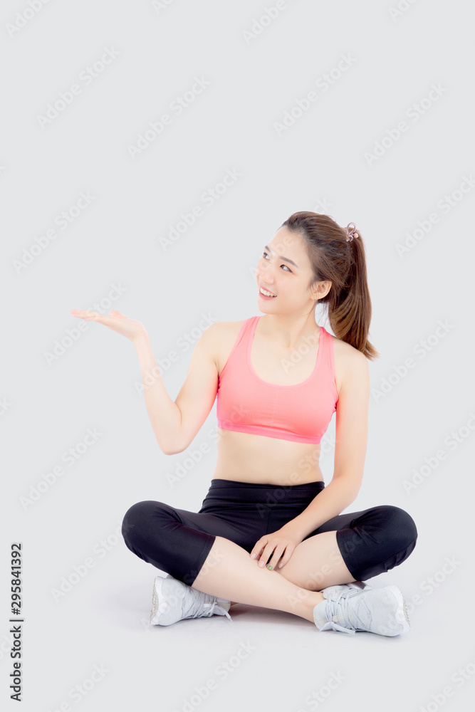 Beautiful portrait young asian woman in sport clothes with satisfied and confident presenting and show something isolated on white background, asia girl sitting exercise for fit with health concept. Beautiful portrait young asian woman in sport clothes with satisfied and confident presenting and show something isolated on white background, asia girl sitting exercise for fit with health concept.