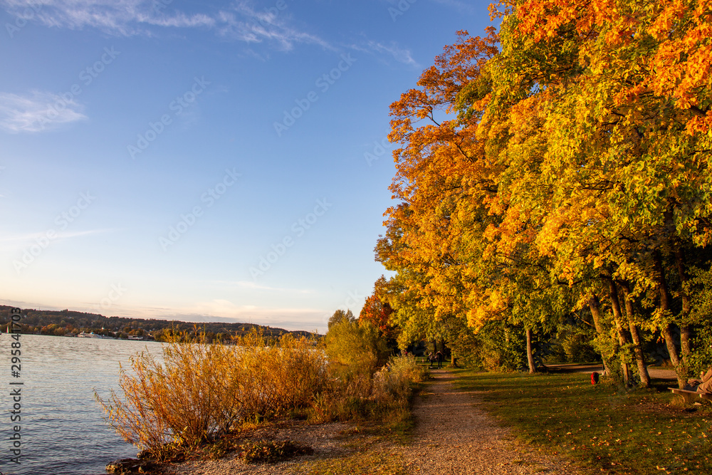 Uferweg am Starnberger See mit buntem Herbstlaub am Abend