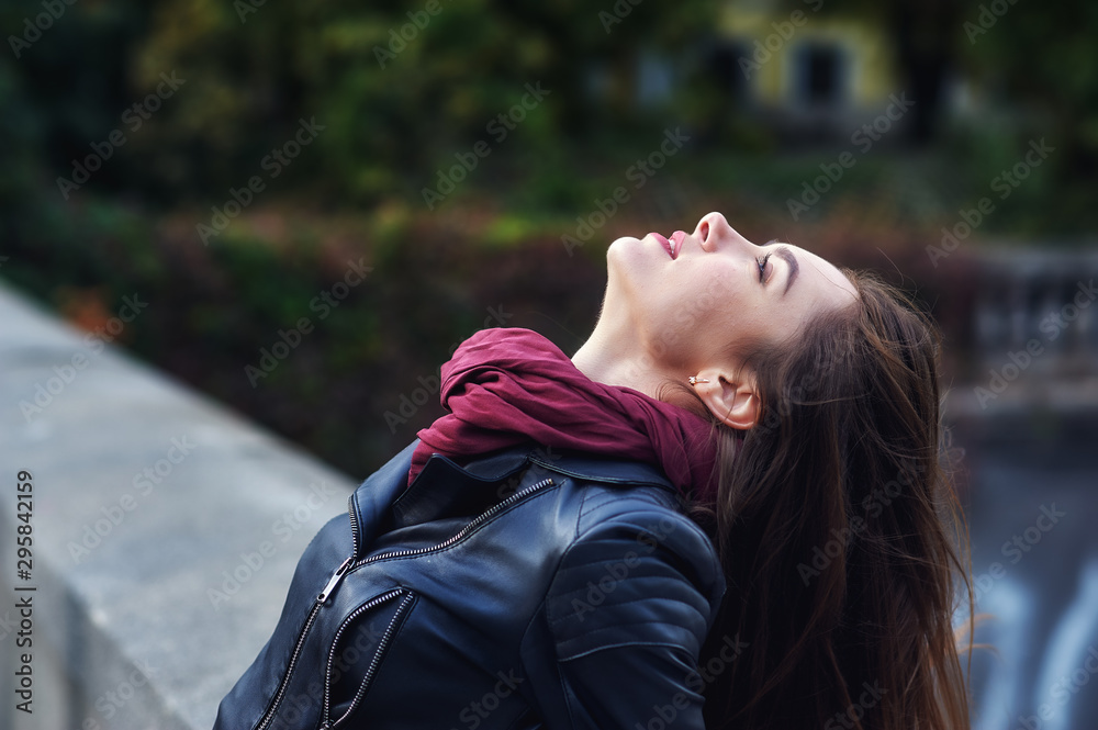 Portrait of a young beautiful woman in the city . Girl in fashionable leather jacket