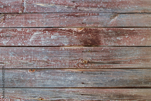 Wooden shabby horizontal planks of the wall or floor of wood construction with a pattern of knots and stains with traces of cut branches painted in dark brown color. Natural textured wooden background