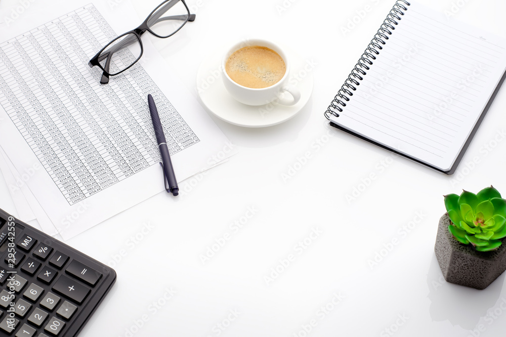 Accounting business concept. Desktop with cup of coffee, calculator, glasses, notepad and spreadsheet.