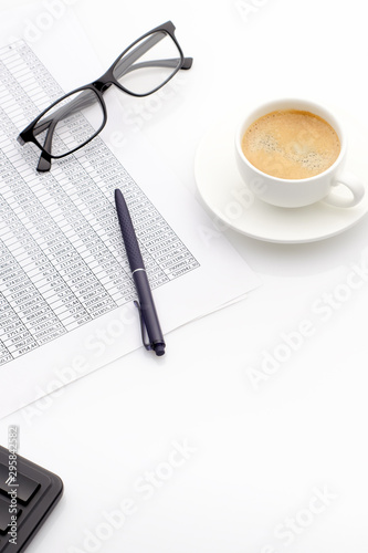 Accounting business concept. Desktop with cup of coffee, calculator, glasses, notepad and spreadsheet.
