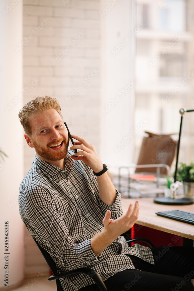 Businessman on call. Young man using phone in office. Businessman on call. Young man using phone in office.