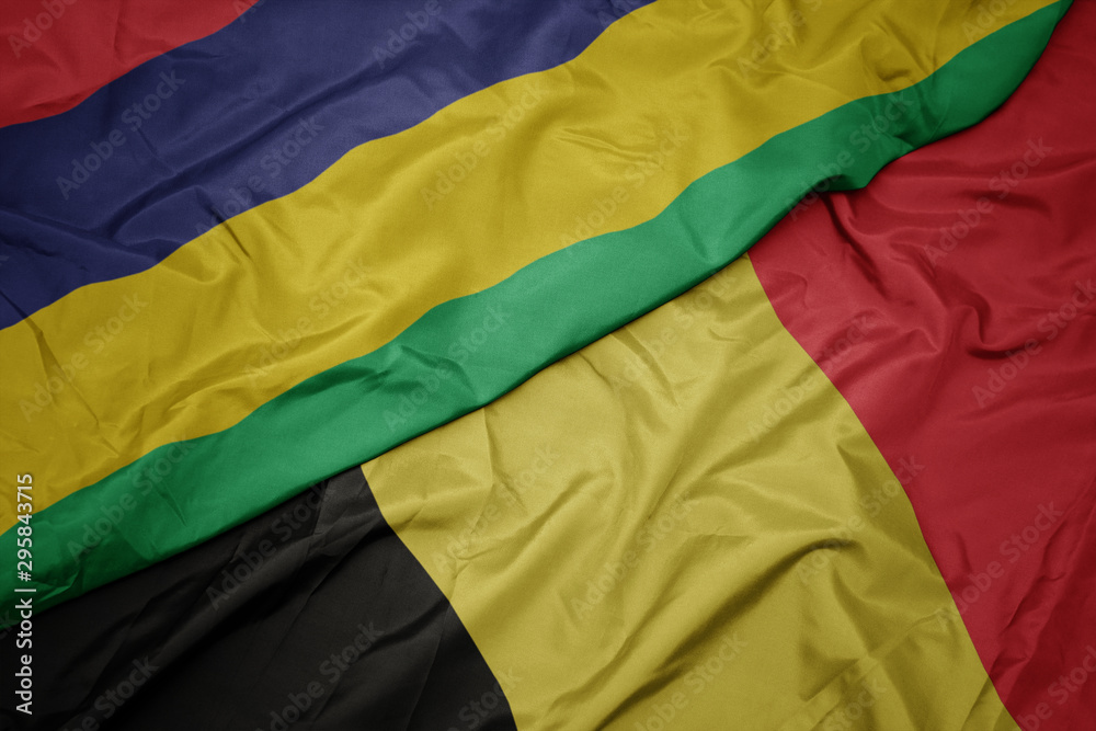 waving colorful flag of belgium and national flag of mauritius. waving colorful flag of belgium and national flag of mauritius.