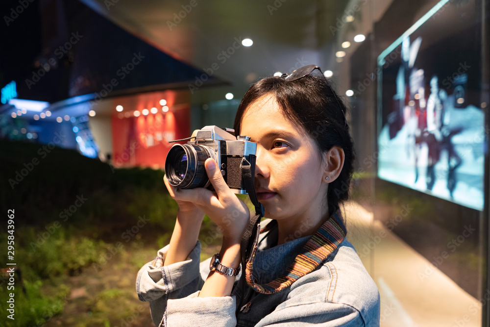 girl photographer In the jean coat take picture at the night with Vintage Film camera