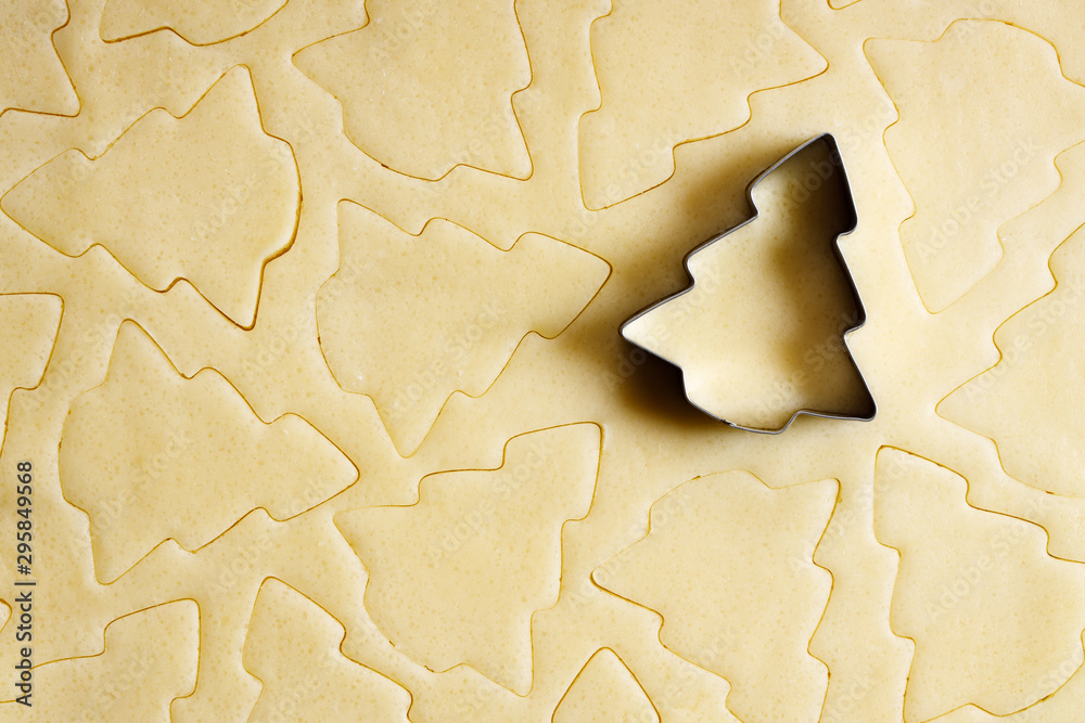 Fototapeta premium Cookie dough with Christmas tree shaped cutter, top view.