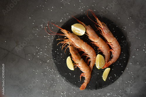 Raw red prawns with lime on a gray background photo